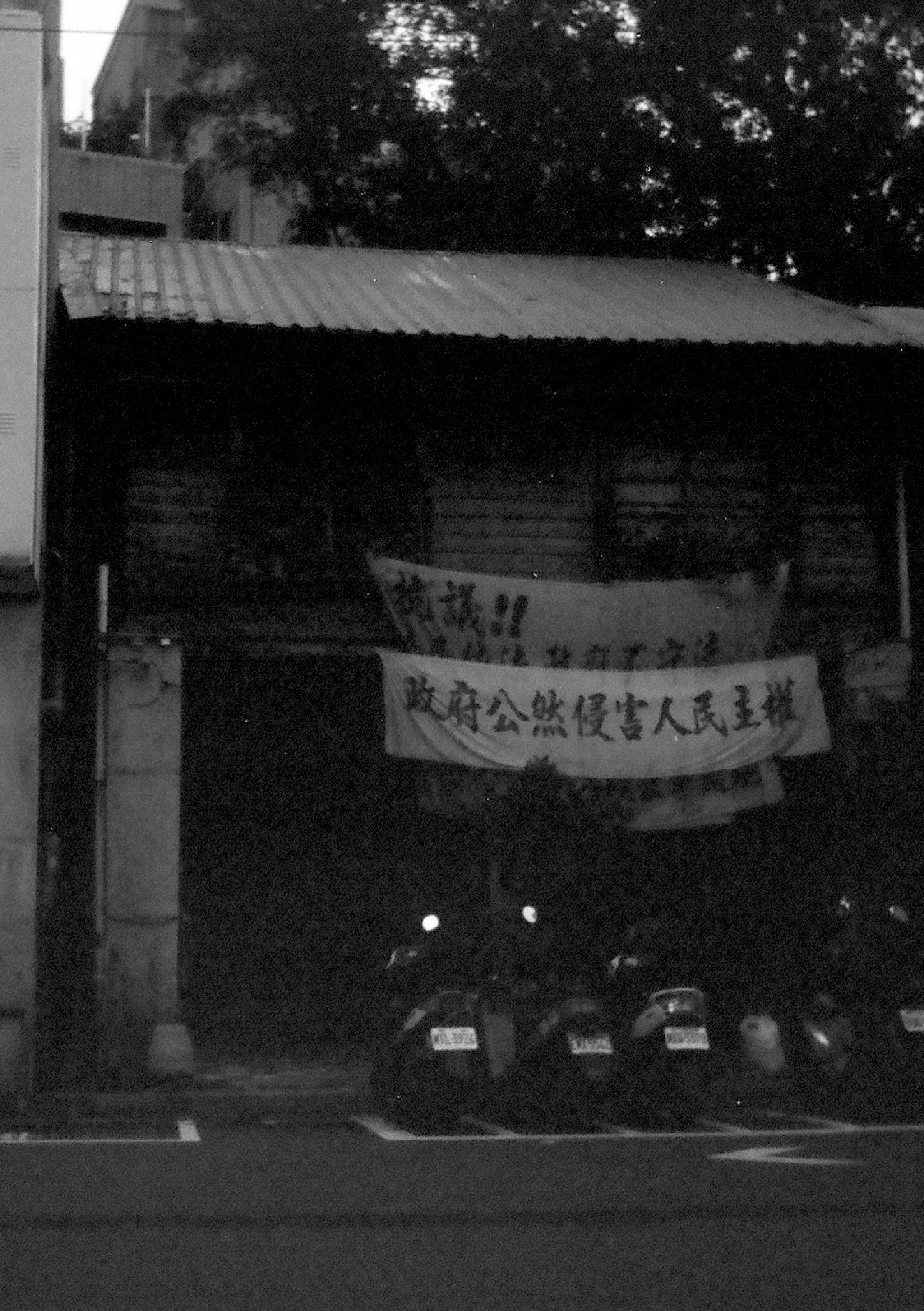 An old, run down building with banners reading 'Protest! The government is attaching civil rights.