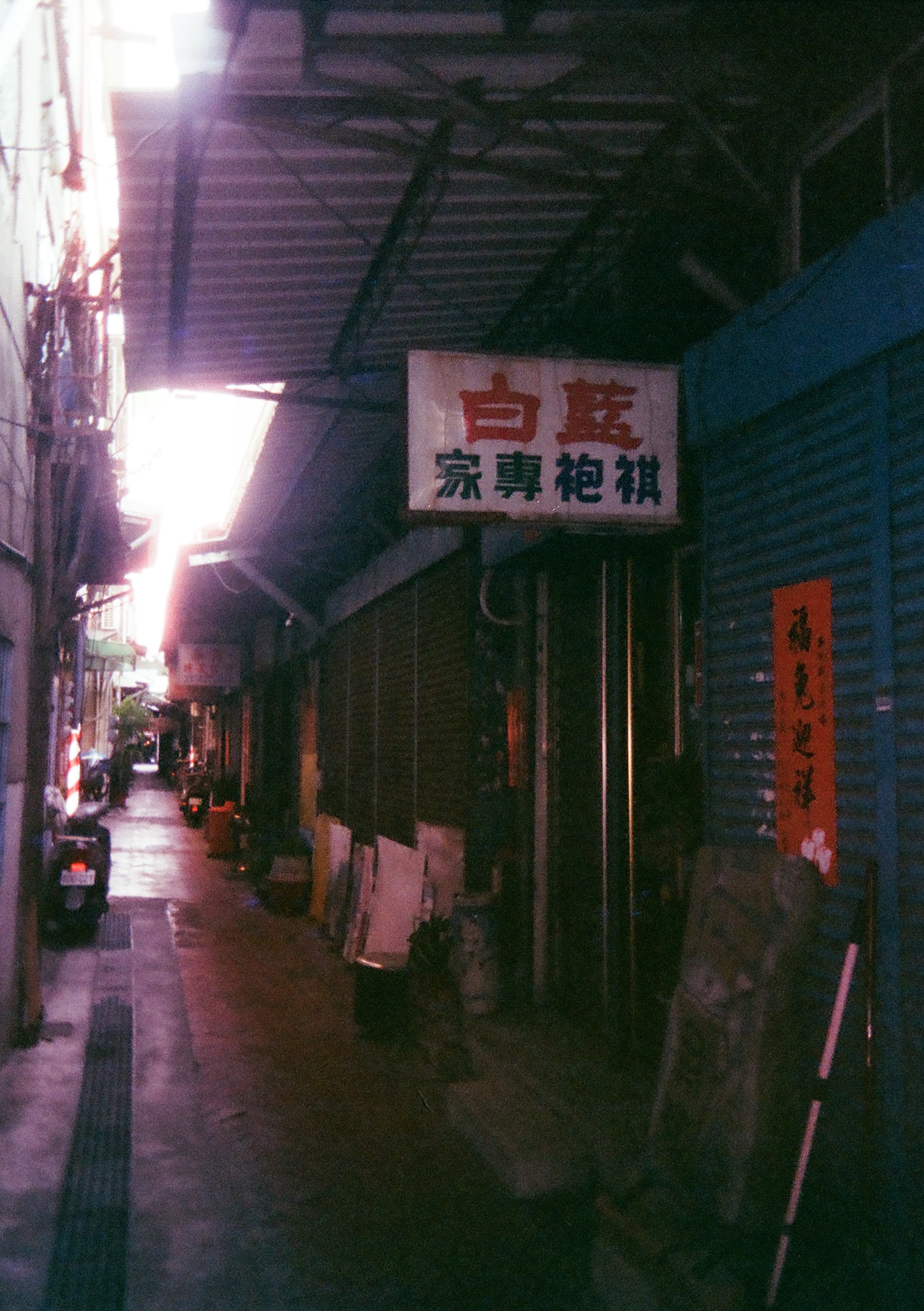 a street with a sign for Blue White Qipao Expert on it 
