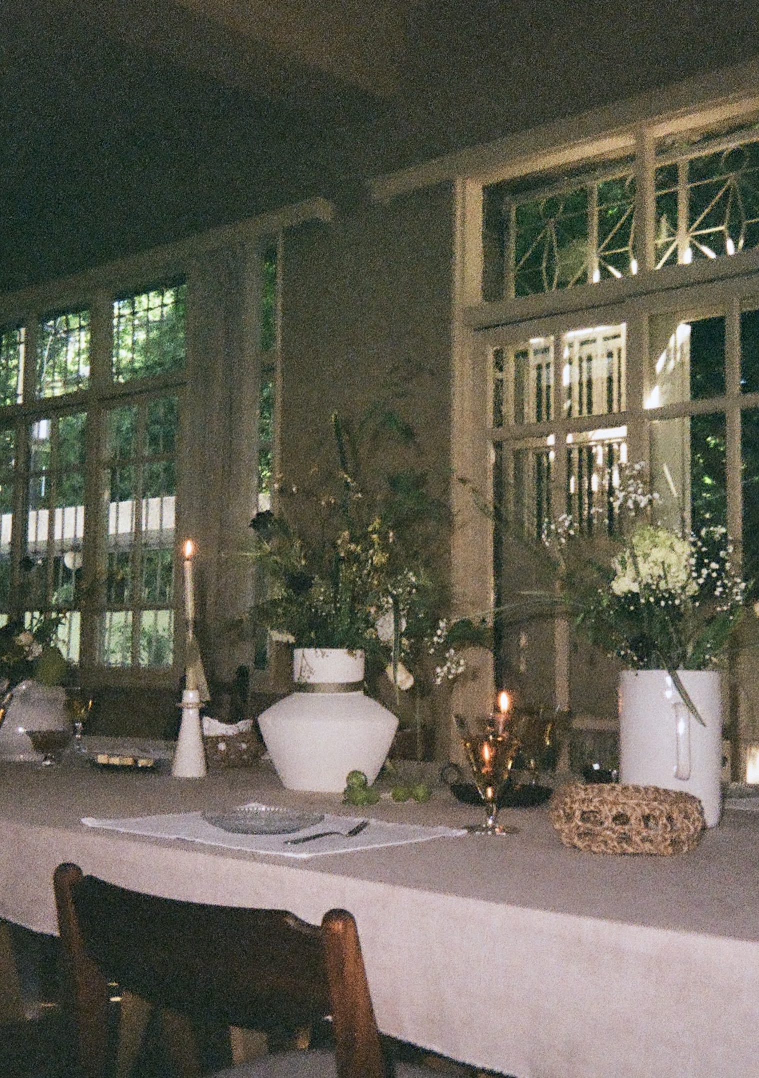 A dining table with decorations, vases, candles.